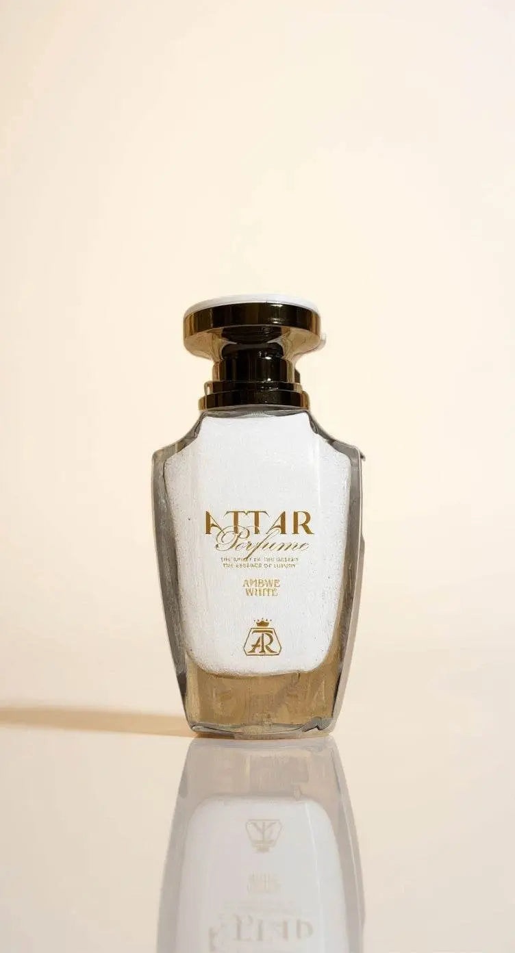 Amber White attar perfume in an elegant clear glass bottle with golden accents, showcasing a luxurious fragrance.