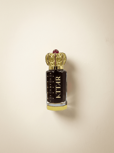 Perfume bottle with decorative cap on a beige background