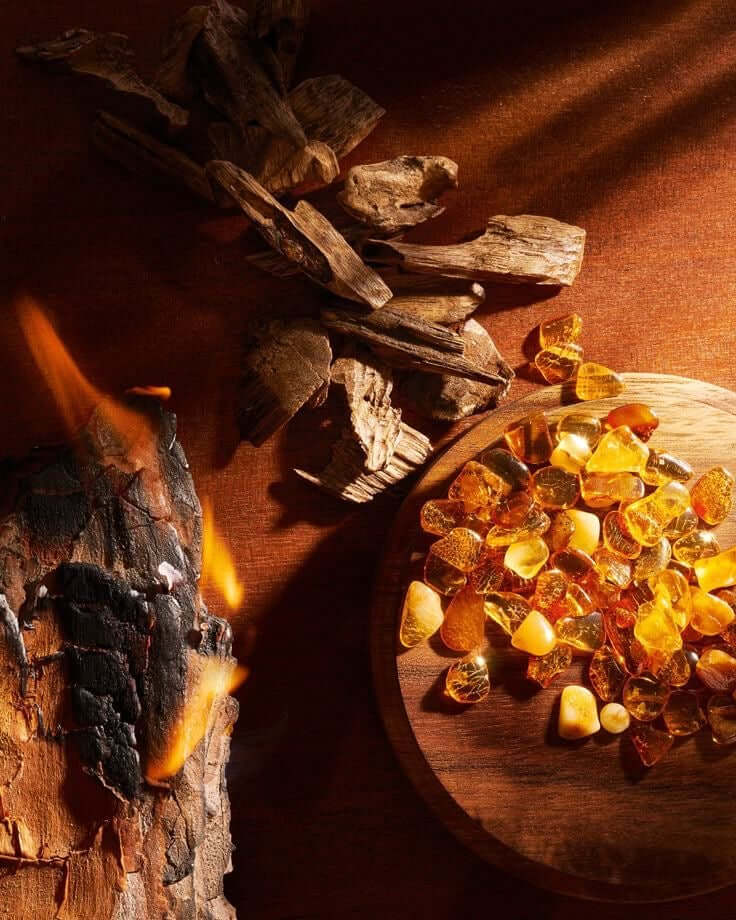 Candle wax beads on a wooden board with burning wood in the background